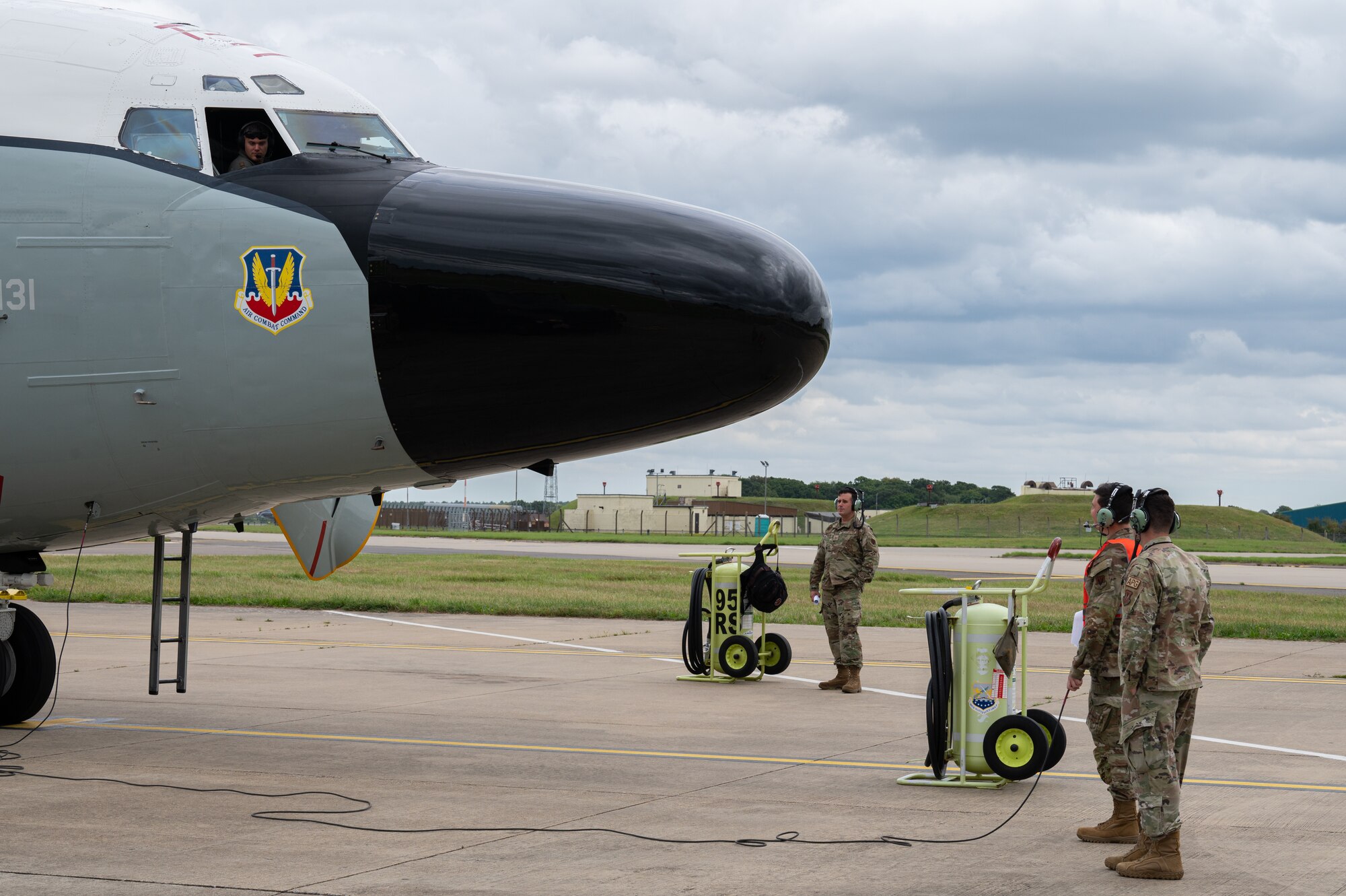 U.S. Air Force Airmen assigned to the 95th Reconnaissance Squadron, assist with procedures during the first hot-pit refueling of a RC-135 Rivet Joint aircraft at Royal Air Force Mildenhall, England, Aug. 14, 2023.