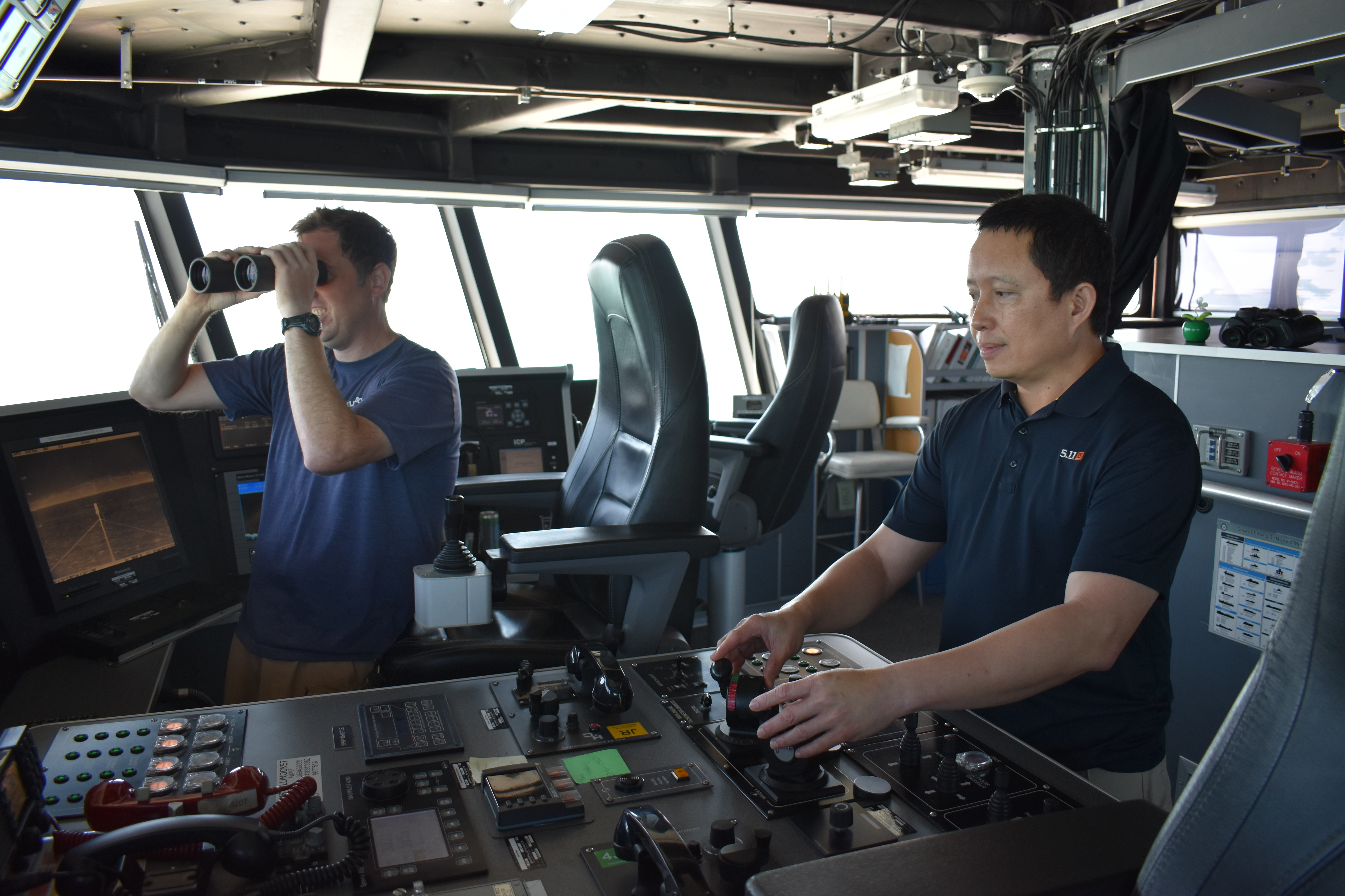 Civilian mariner Capt. Erwin F. Lao, right, USNS Millinocket’s master, maneuvers Military Sealift Command’s expeditionary fast transport USNS Millinocket prior to launching the fast rescue boat, while assisted by Chief Mate Jeffrey A. Motl while rendering assistance to a small craft in distress in the vicinity of Darwin, Australia, August 8.