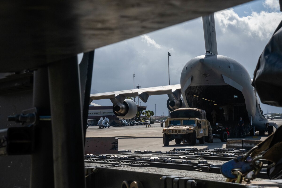 An U.S. Army High Mobility Multipurpose Wheeled Vehicles (HMMWVs) is loaded onto a C-17 Globemaster III during an exercise at Joint Base Pearl Harbor-Hickam, Hawaii, August 1, 2023. Airmen from the 535th Airlift Squadron, 735th Airlift Air Mobility Squadron and 48th Aerial Port Squadron worked together to load and secure cargo on the C-17 in support of Exercise Mungadai, a field artillery exercise. (U.S Air Force photo by Senior Airman Makensie Cooper)