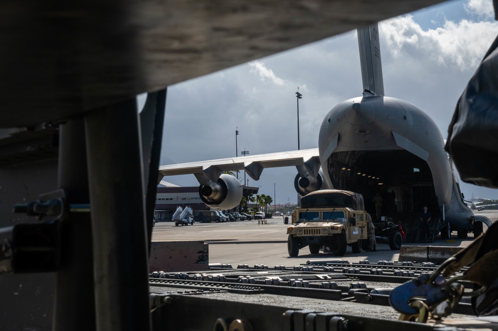 An U.S. Army High Mobility Multipurpose Wheeled Vehicles (HMMWVs) is loaded onto a C-17 Globemaster III during an exercise at Joint Base Pearl Harbor-Hickam, Hawaii, August 1, 2023. Airmen from the 535th Airlift Squadron, 735th Airlift Air Mobility Squadron and 48th Aerial Port Squadron worked together to load and secure cargo on the C-17 in support of Exercise Mungadai, a field artillery exercise. (U.S Air Force photo by Senior Airman Makensie Cooper)