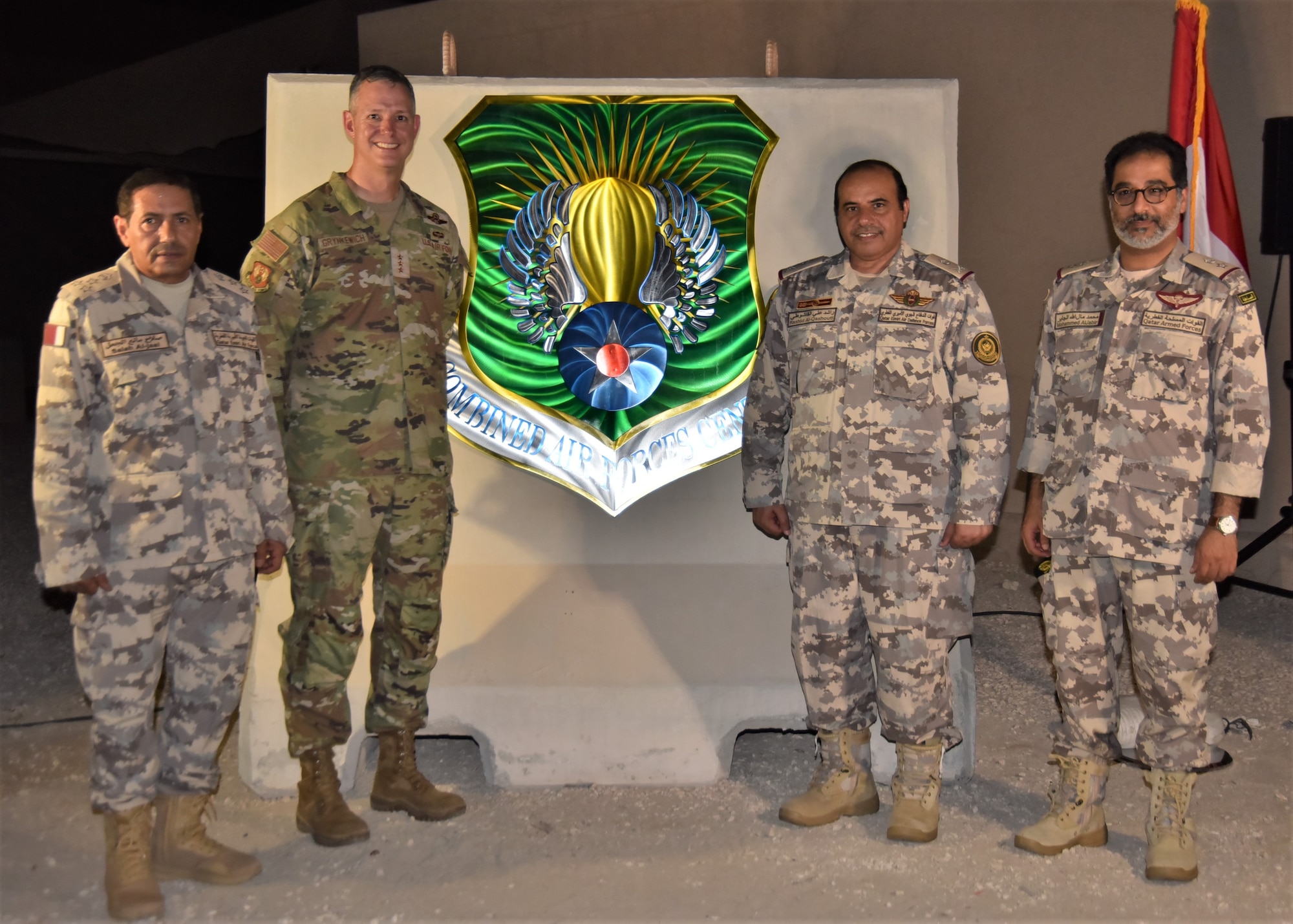U.S. Air Force Lt. Gen. Alex Grynkewich, Ninth Air Force (AFCENT) commander and Combined Forces Air Component Commander (CFACC) for U.S. Central Command,
center-left, Qatari Air Force staff Brig. Gen. Salah Manea Al-Jaal, Al Udeid Air Base commander, left, staff Maj. Gen. Rashid Ali Al-Qashouti, Qatari Emiri Air Defense Force commander, center-right, and staff Lt. Col. Mohamed Malallah Al-Jabir, acting director of International Forces Affairs directorate, right, pose for a photo during the unveiling of the new coalition and combined forces central emblem August 16, 2023, at Al Udeid Air Base, Qatar
