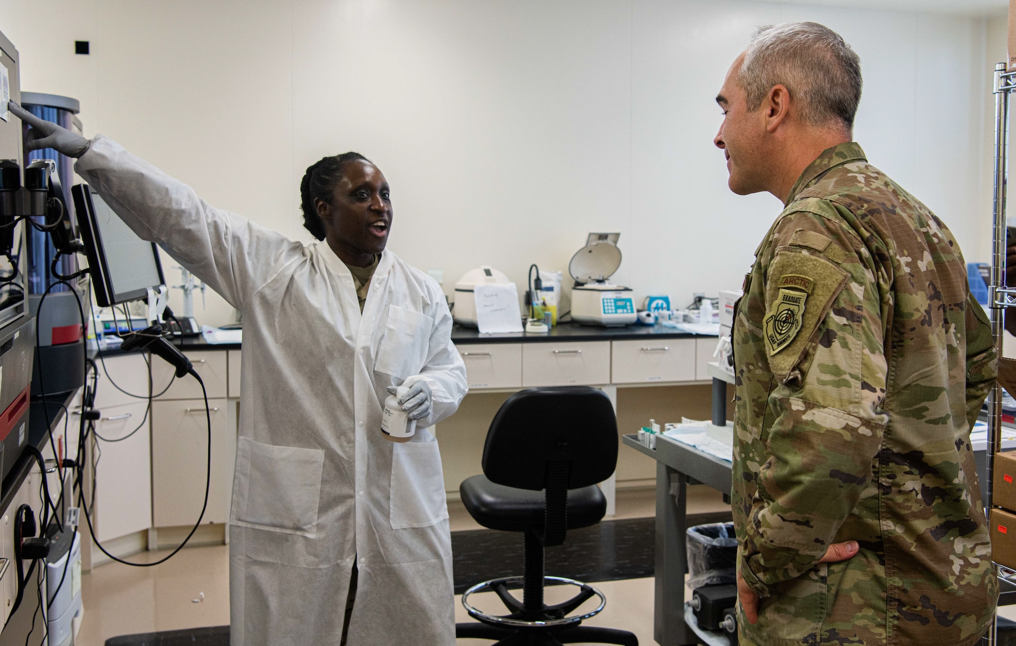 U.S. Army Staff Sgt. Shameka Miller, Armed Service Blood Bank Center laboratory technician, discusses the blood testing process with U.S. Air Force Chief Master Sgt. Kristopher Berg, 11th Air Force command chief.