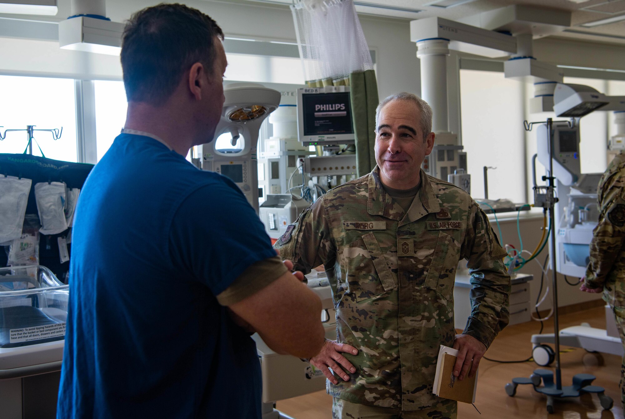 U.S. Air Force Chief Master Sgt. Kristopher Berg, 11th Air Force command chief, speaks with U.S. Air Force Maj. Mathew Huard, Neonatal Intensive Care Unit clinical nurse.