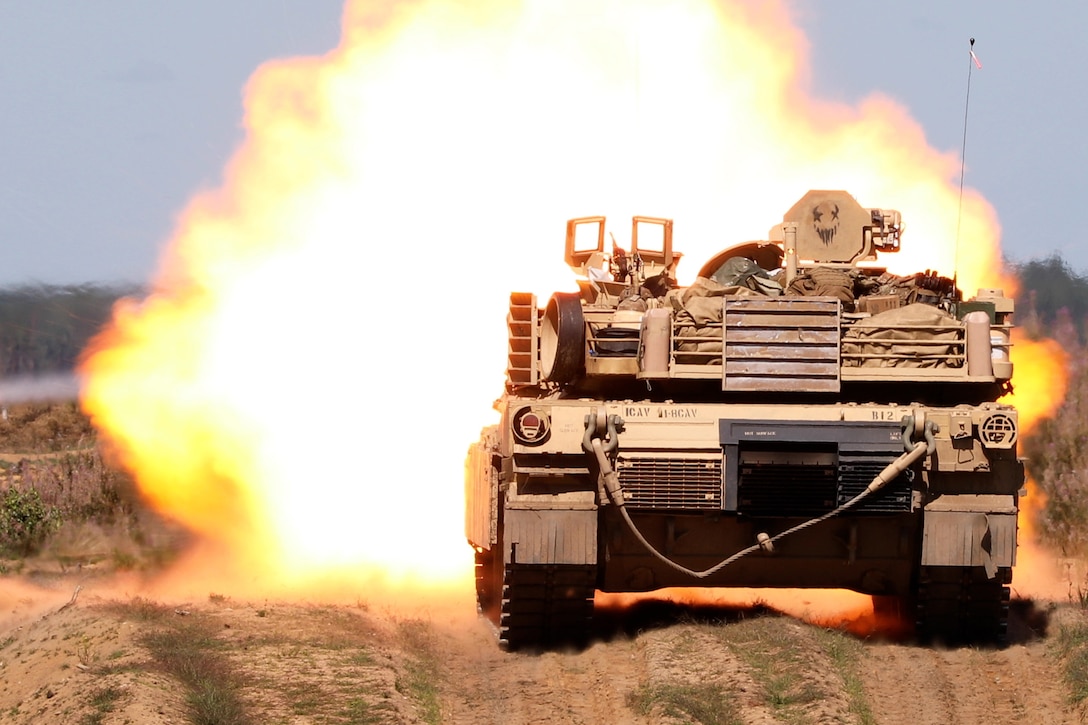 An Army tank crew drives an M1A2 Abrams tank down a road during live-fire qualifications.