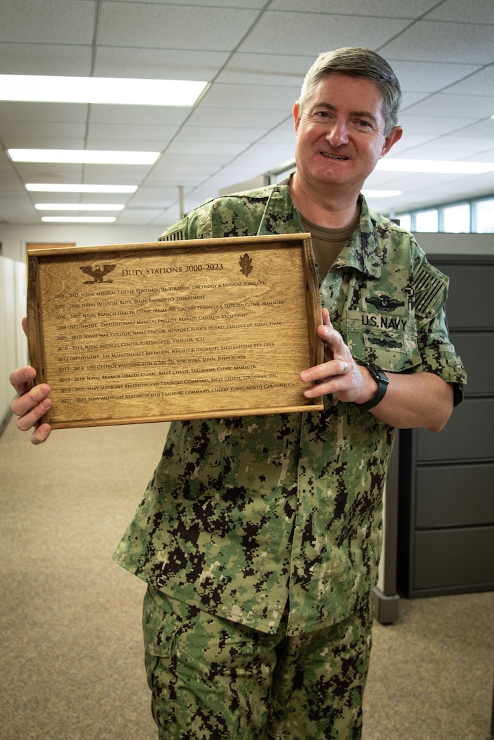 Navy Capt. Phillip Boyer holds up a tray engraved with the duty stations and deployments he served in during his 20-year career as a Navy Nurse.  Boyer retired from U.S. Navy service as Chief Nursing Officer aboard Naval Health Clinic Cherry Point in mid-summer, 2023.