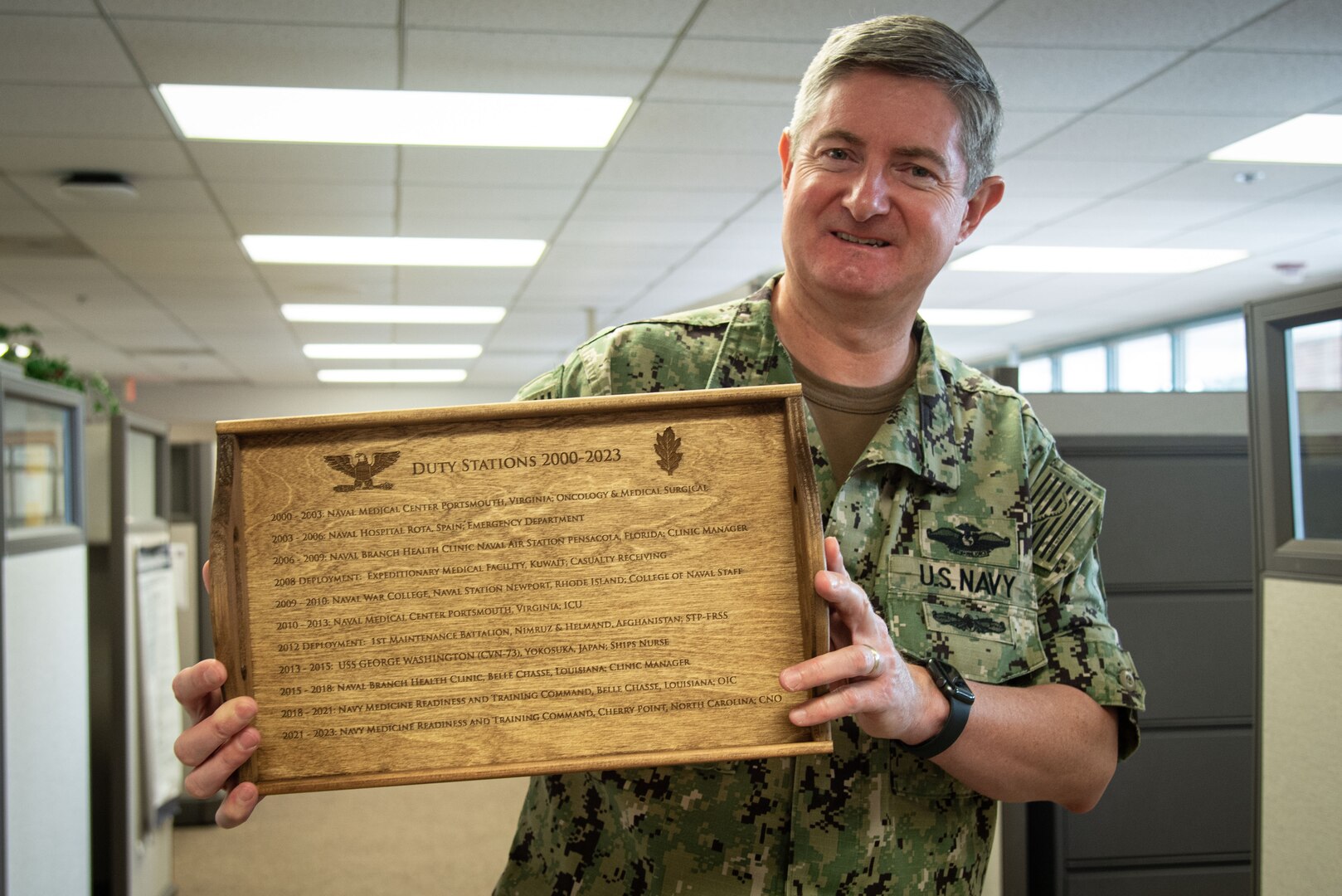 Navy Capt. Phillip Boyer holds up a tray engraved with the duty stations and deployments he served in during his 20-year career as a Navy Nurse.  Boyer retired from U.S. Navy service as Chief Nursing Officer aboard Naval Health Clinic Cherry Point in mid-summer, 2023.