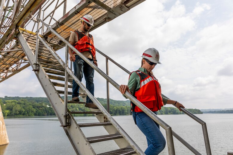 A helicopter lifting trees and concrete blocks to place them in a water basin on the Ohio River.