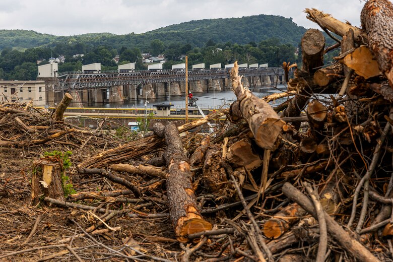 A helicopter lifting trees and concrete blocks to place them in a water basin on the Ohio River.