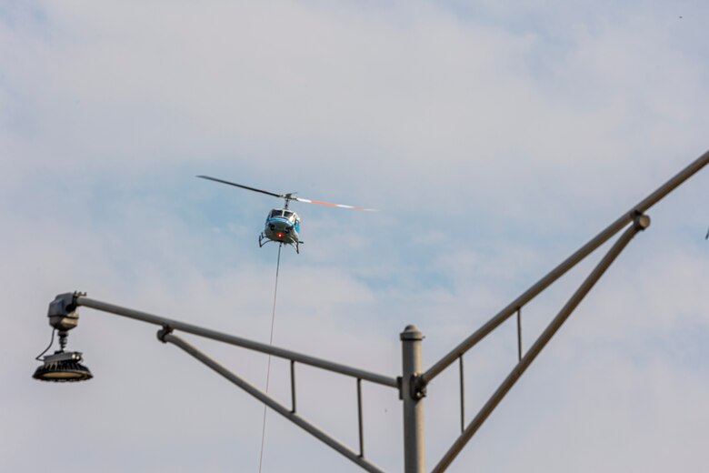 A helicopter lifting trees and concrete blocks to place them in a water basin on the Ohio River.