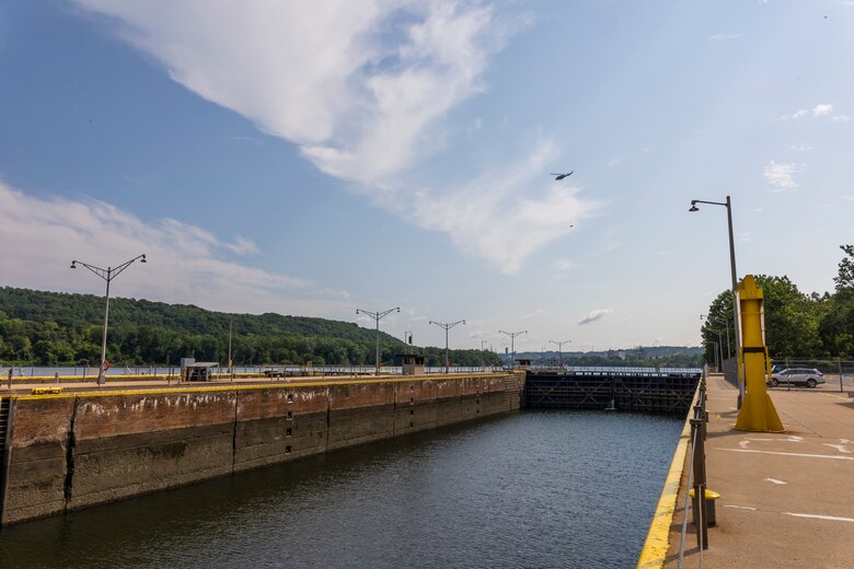A helicopter lifting trees and concrete blocks to place them in a water basin on the Ohio River.