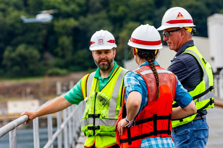 A helicopter lifting trees and concrete blocks to place them in a water basin on the Ohio River.