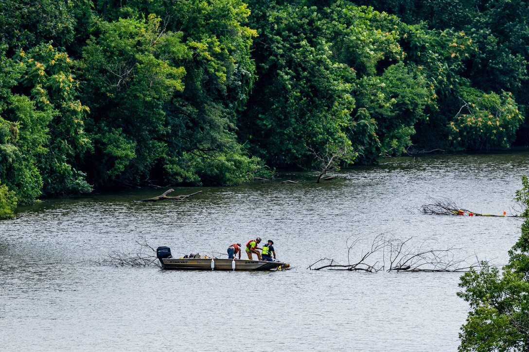 A helicopter lifting trees and concrete blocks to place them in a still water basin on the Ohio River.