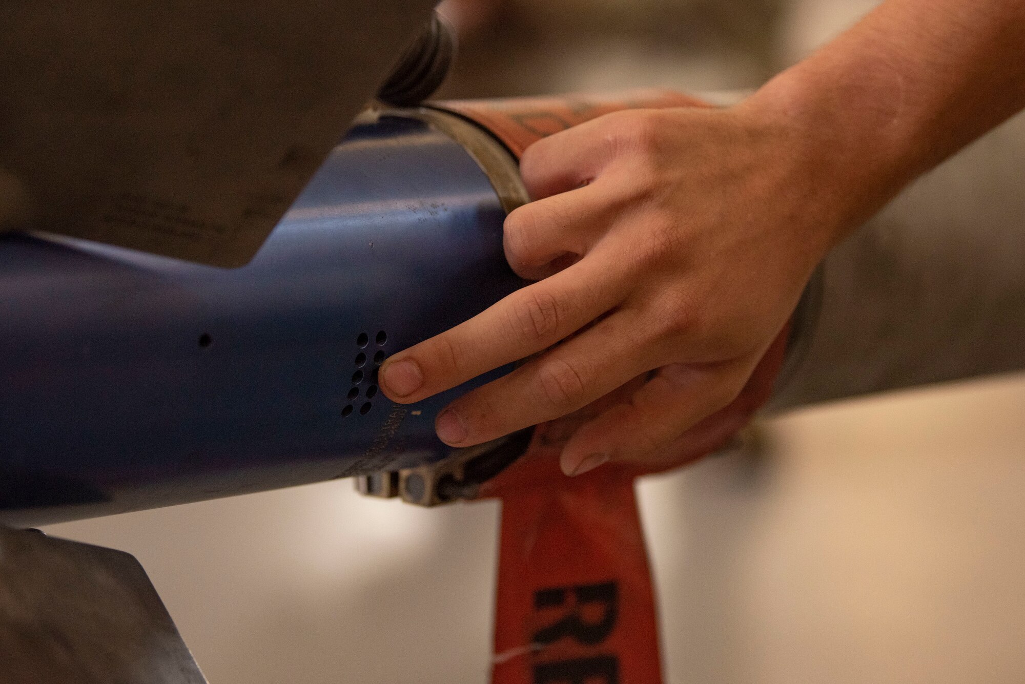 A U.S. Air Force Airman inspects the body of an AIM-9 Missile during a routine munitions training inspection at Moody Air Force Base, Georgia, August 15, 2023. Munitions are routinely inspected to ensure proper functionality and safety. (U.S. Air Force photo by Staff Sgt. Thomas Johns)