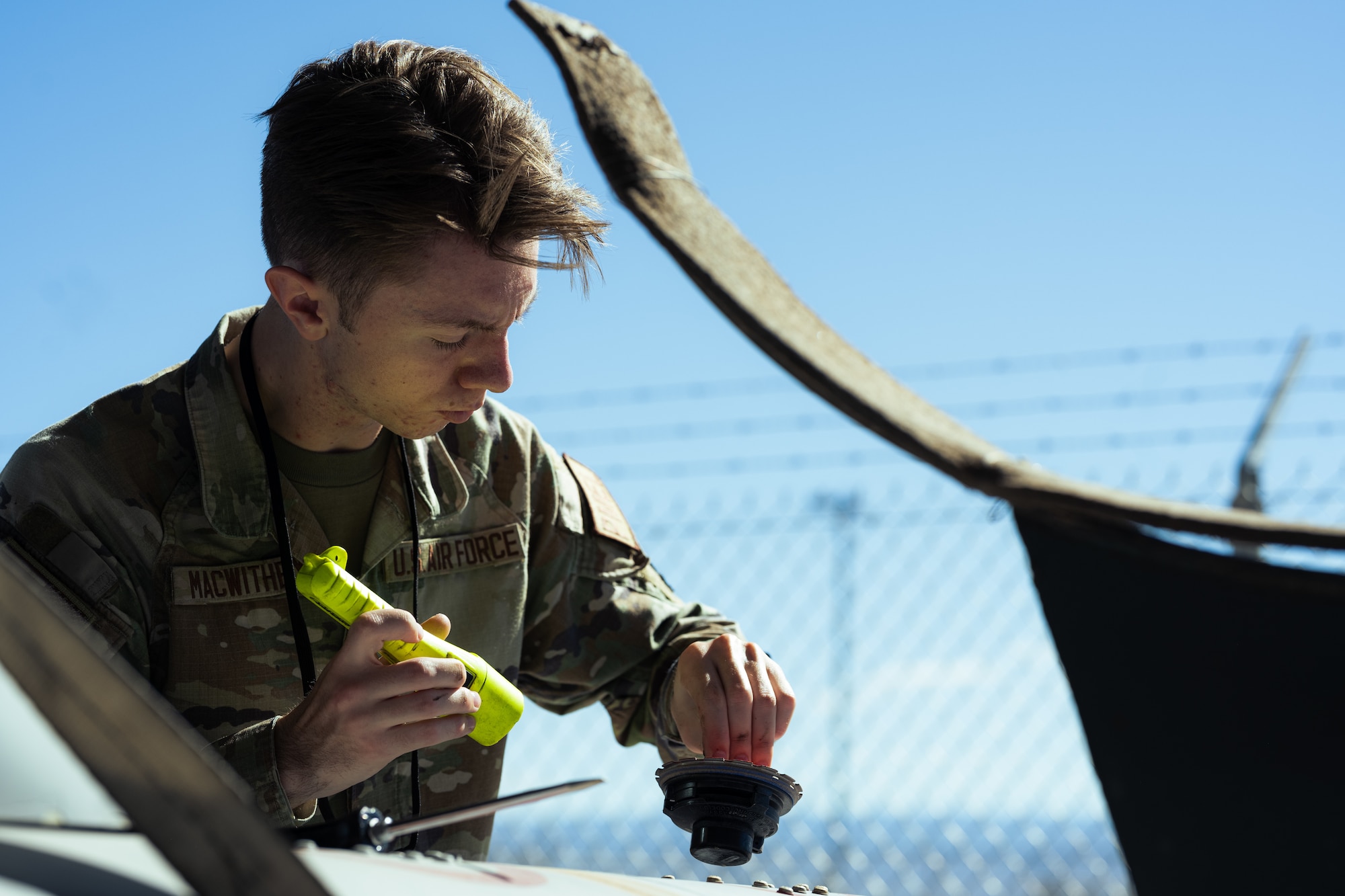 U.S. Air Force Airman 1st Class Alexander MacWithey, 49th Component Maintenance Squadron precision measurement equipment laboratory journeyman, inspects the fuel cap of an F-16 Viper external fuel tank at Holloman Air Force Base, New Mexico, Aug. 10, 2023. This training helps to create Airmen who are skilled in different areas, but it also fills any personnel gaps. (U.S. Air Force photo by Senior Airman Antonio Salfran)