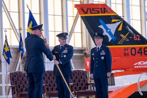 Brig. Gen. Matthew Higer, the outgoing 412th Test Wing Commander, relinquishes his command of the Wing by returning the unit’s guidon to Maj. Gen. Evan Dertien, Air Force Test Center commander, during the Wing’s Change of Command Ceremony at Edwards Air Force Base, California, Aug.18.