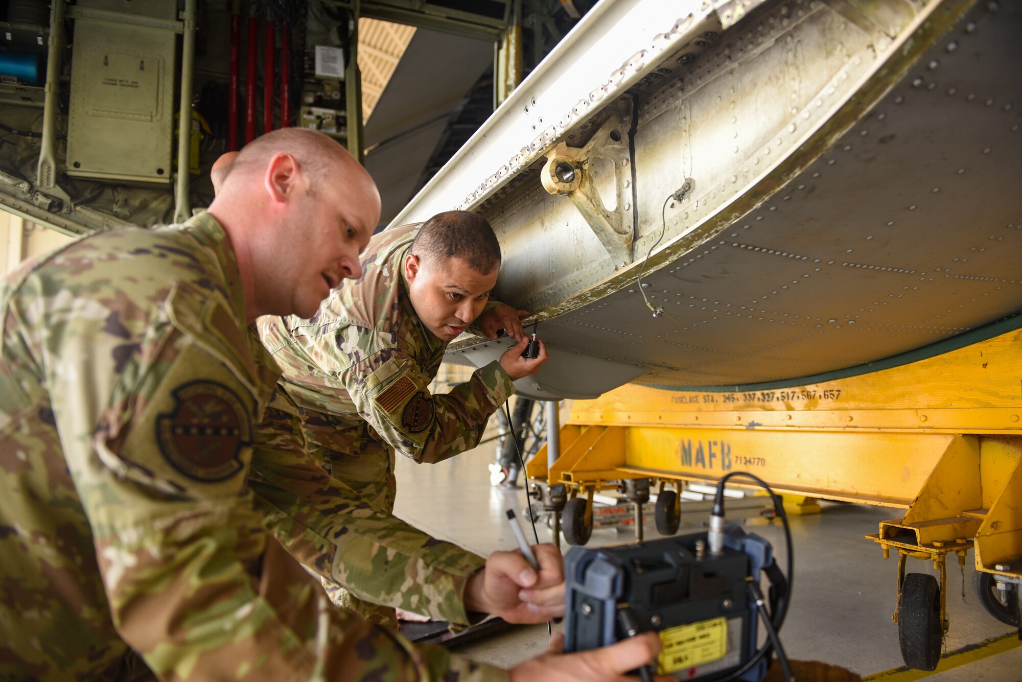 U.S. Air Force Airmen from the 71st Rescue Generation Squadron nondestructive inspection shop use an Eddy Current Probe during a corrosion inspection of an HC-130J Combat King II at Moody Air Force Base, Georgia Aug. 10, 2023. The probe uses electromagnetic currents to locate cracks within the metal of the aircraft. (U.S. Air Force photo by Senior Airman Courtney Sebastianelli)