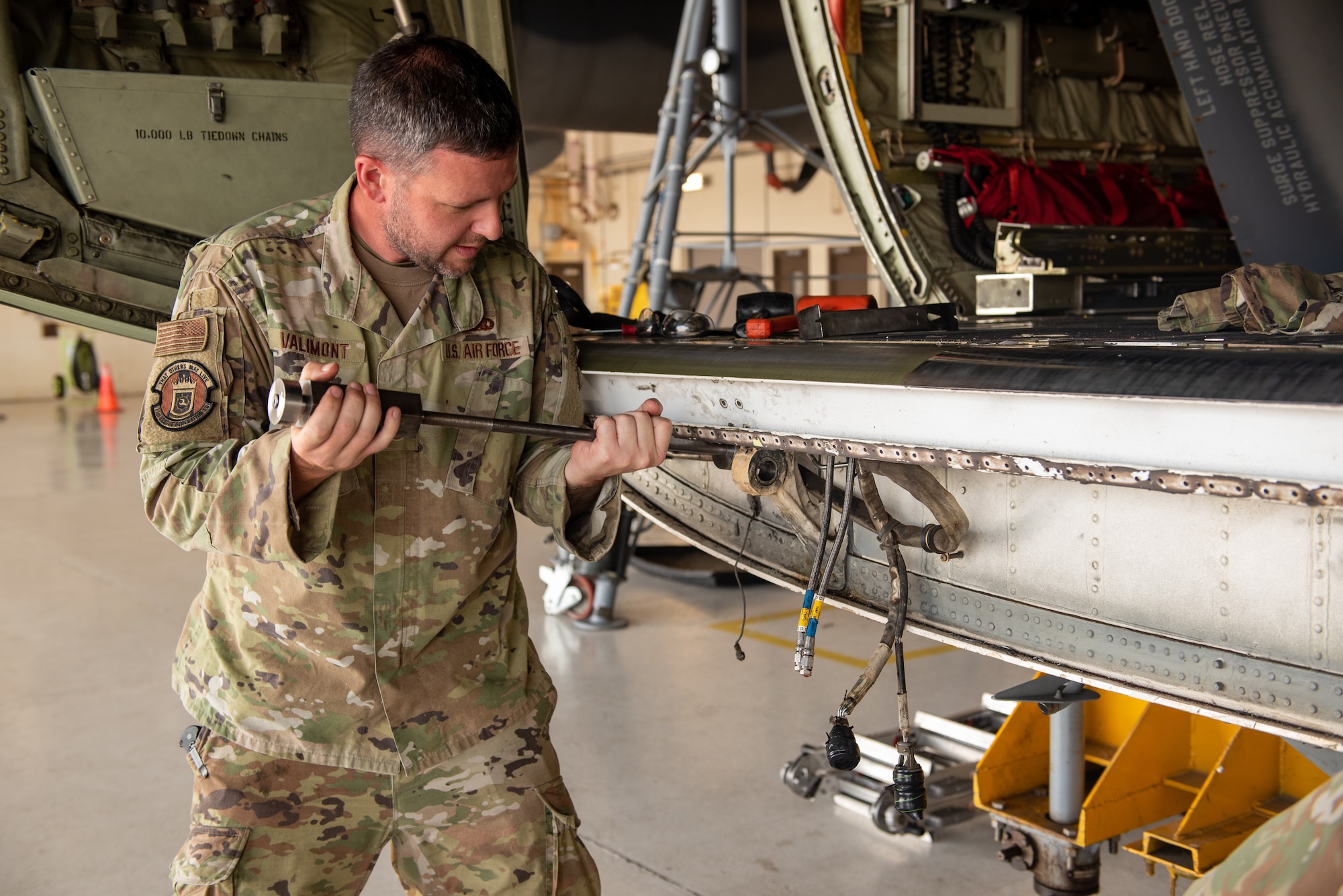 U.S. Air Force Tech. Sgt. Micah Valimont, 71st Rescue Generation Squadron repair and reclamation noncommissioned officer in charge, pushes a slide hammer into the bulkhead area of an HC-130J Combat King II at Moody Air Force Base, Georgia, Aug. 10, 2023. During maintenance, the aircraft was systematically disassembled for in-depth corrosion repair. (U.S. Air Force photo by Senior Airman Courtney Sebastianelli)