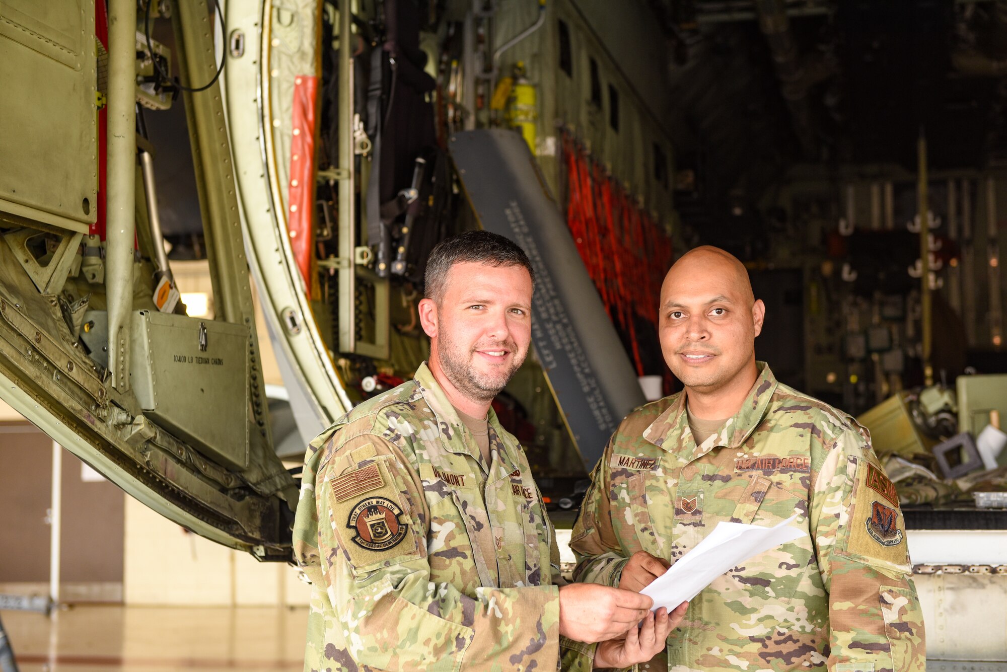 U.S. Air Force Tech. Sgt. Micah Valimont, 71st Rescue Generation Squadron repair and reclamation noncommissioned officer in charge, (left) and Tech. Sgt Kenneth Martinez, 23rd Maintenance Squadron aircraft structural maintenance section chief, smile for a photo at Moody Air Force Base, Georgia, Aug. 10, 2023. Both Airmen provided support to the inspection and deconstruction of an aircraft to ensure the safety of pilots and aircrew during flight. (U.S. Air Force photo by Senior Airman Courtney Sebastianelli)