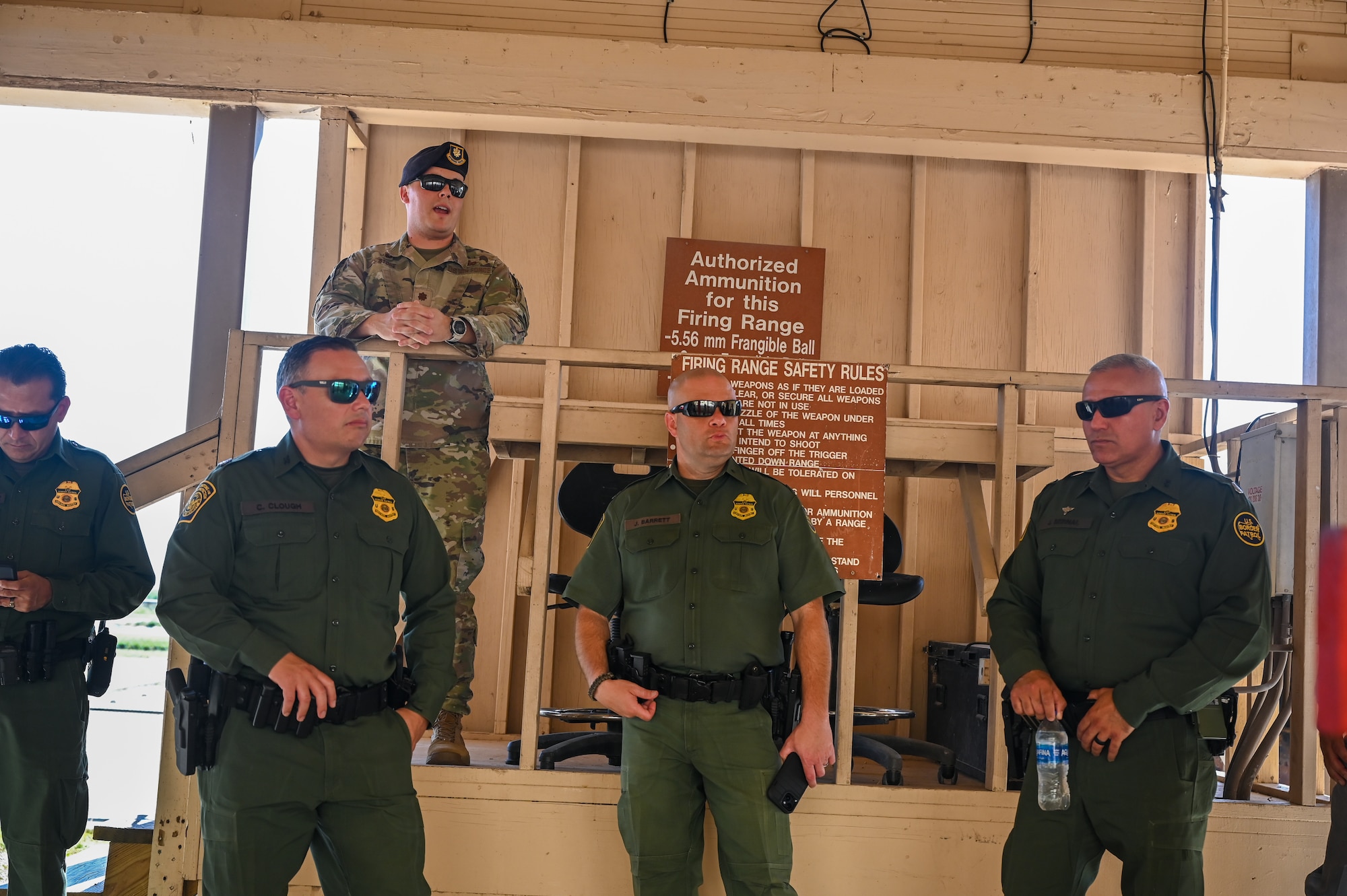U.S. Air Force Maj. Robert Stone, 47th Security Forces Squadron commander (top left), speaks to tour participants about the capabilities of the Combat Arms Training and Maintenance (CATM) range during a base tour with the U.S. Border Patrol Del Rio Sector leadership and the Val Verde County Sheriff's Department at Laughlin Air Force Base, Texas, Aug. 4, 2023. The 47th SFS Defenders showcased various safety and security capabilities during the visit. (U.S. Air Force photo by Airman 1st Class Keira Rossman)