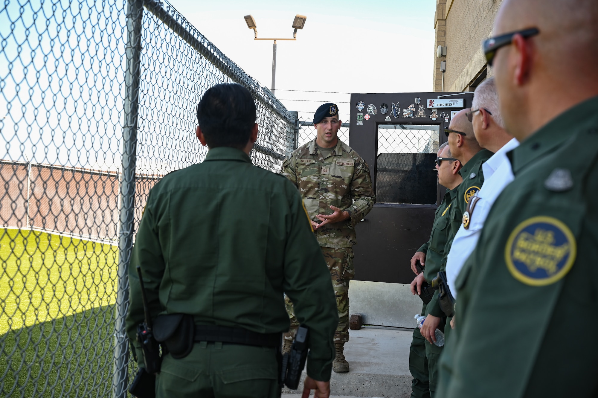 U.S. Air Force Tech. Sgt. William Slifer, 47th Security Forces Squadron kennel master, speaks to visitors about the K-9 training facilities during a base tour with the U.S. Border Patrol Del Rio Sector leadership and the Val Verde County Sheriff's Department at Laughlin Air Force Base, Texas, Aug. 4, 2023. The K-9 demonstration showcased the capabilities and preparedness of Laughlin’s Defenders. (U.S. Air Force photo by Airman 1st Class Keira Rossman)