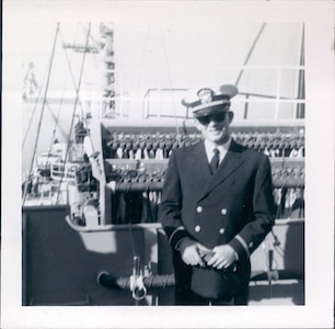 Lt. j.g. William Collins stands in front of the signal station onboard the USS Newport News (CA-148).