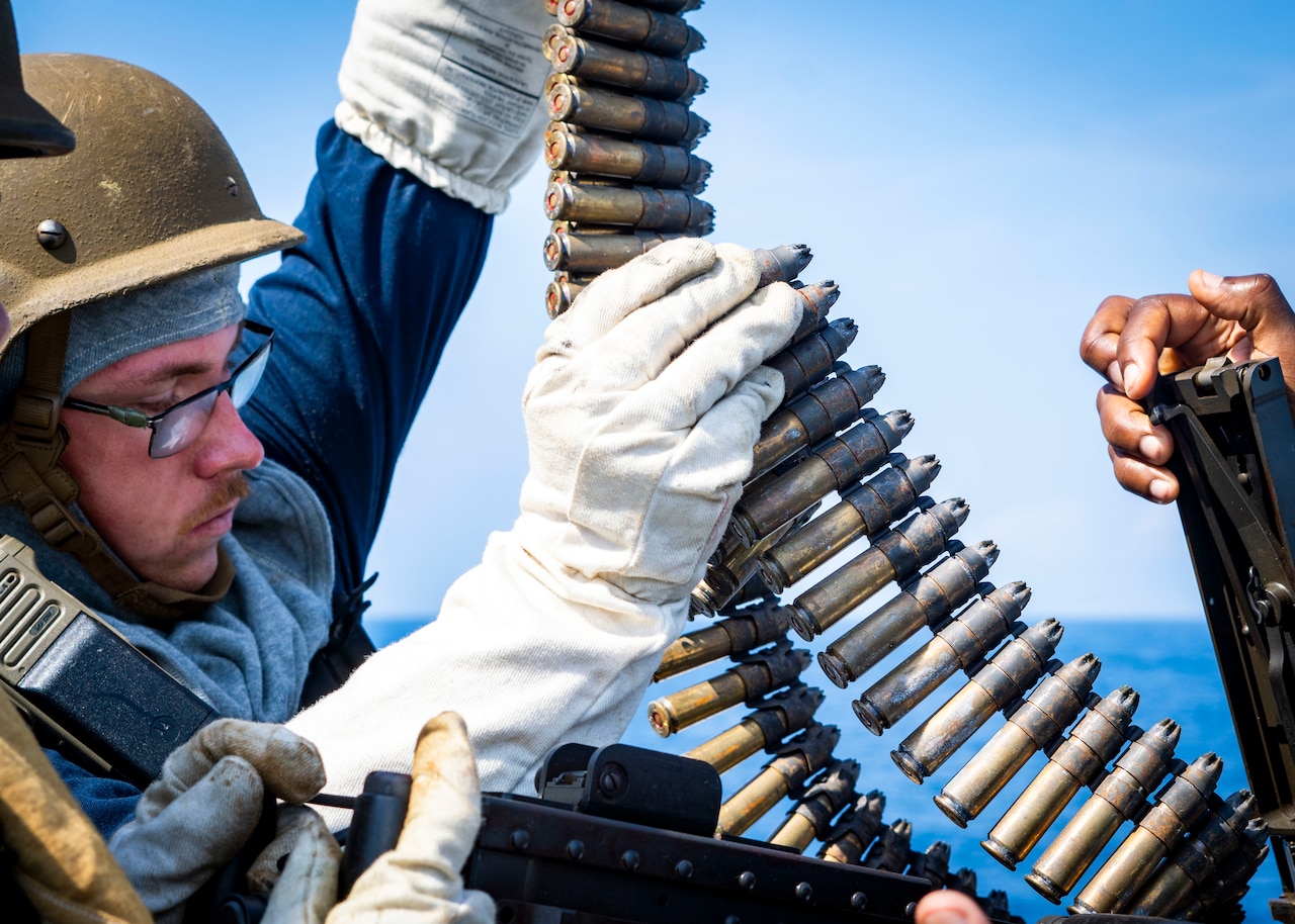 A sailor loads rounds into a weapon.