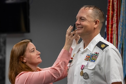 Tabitha Sturgill puts new rank on Command Sgt. Maj. John J. O’Connor, USAFMCOM Operations senior enlisted advisor, during his appointment ceremony at the Maj. Gen. Emmett J. Bean Federal Center in Indianapolis Aug. 11, 2023. O’Connor was appointed to command sergeant major from sergeant major prior to his upcoming move to serve at the Warrior Transition Unit at Fort Belvoir, Virginia. (U.S. Army photo by Mark R. W. Orders-Woempner)