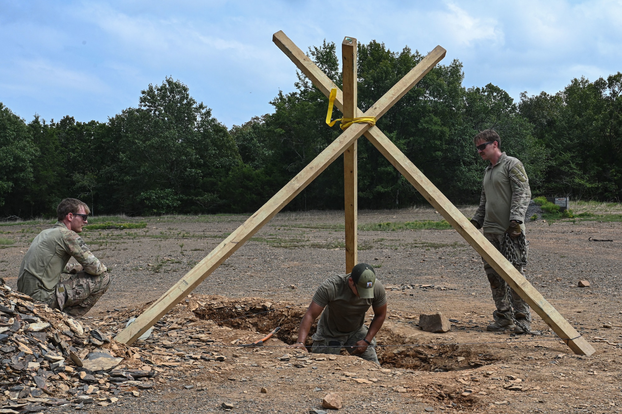 men in uniform prepare to lift a simulated bomb shell