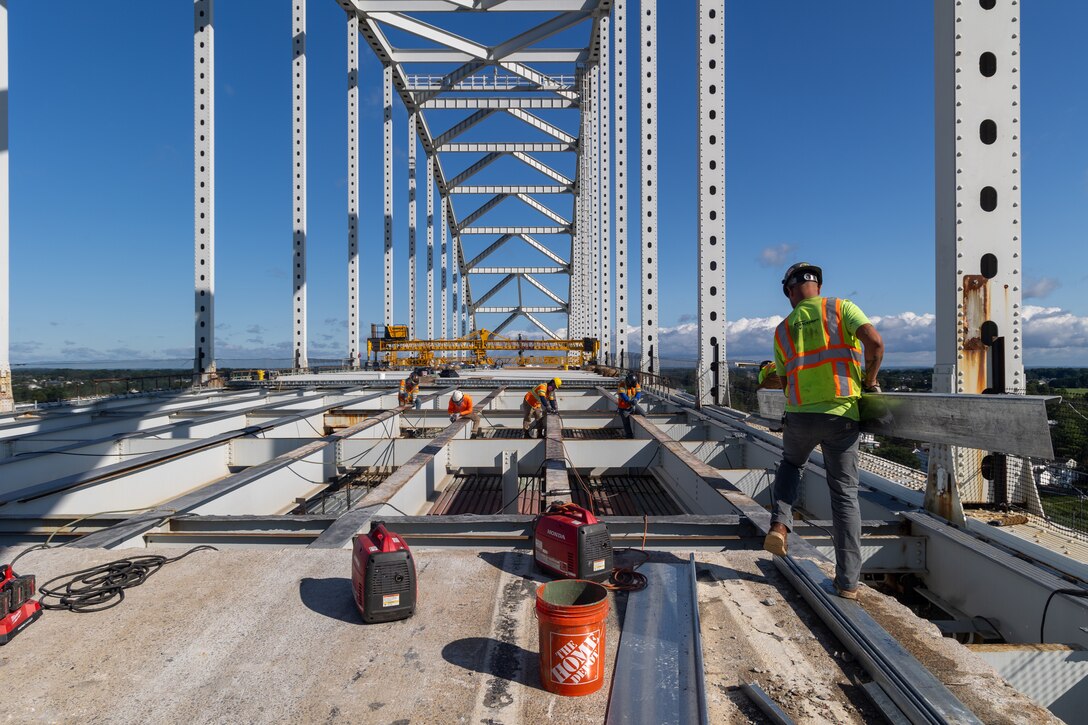 Photo shows contractors working on a bridge