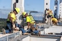 Photo shows contractors working on a bridge