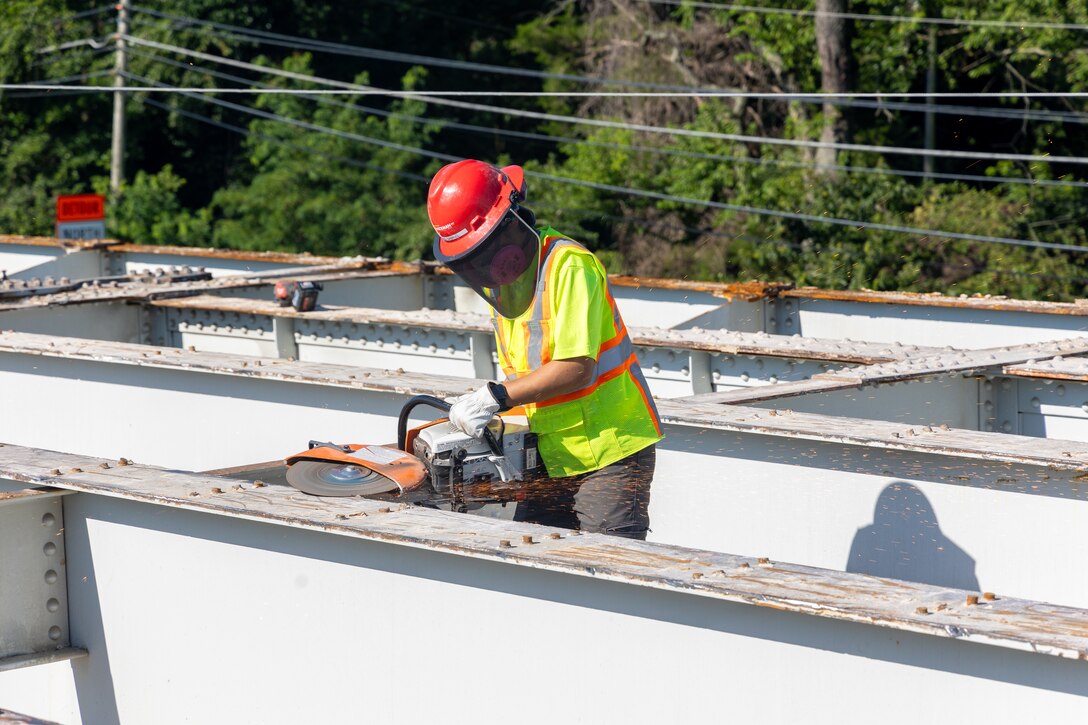 Photo shows contractors working on a bridge