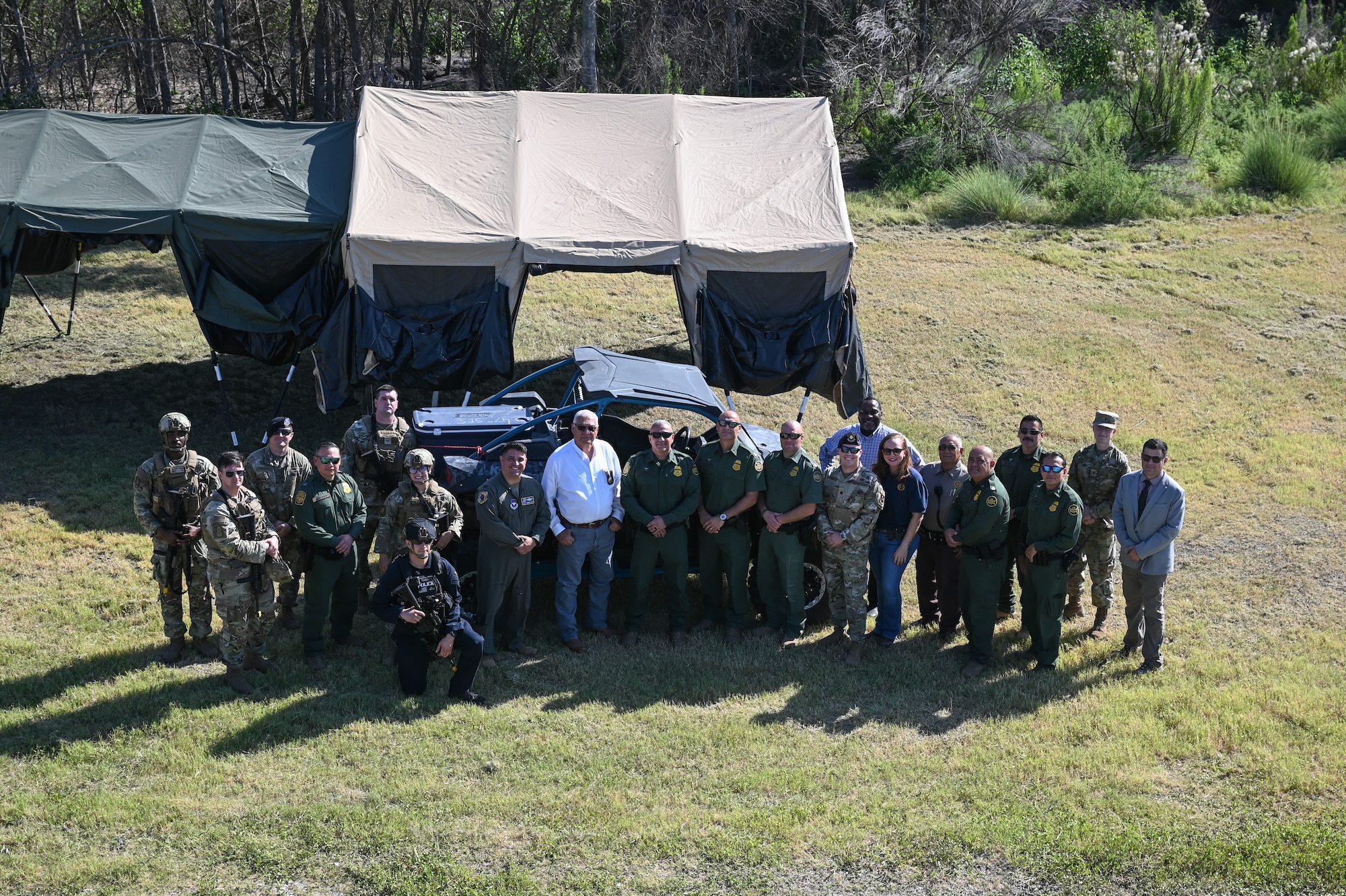 U.S. Air Force Airmen, U.S. Border Patrol Del Rio Sector leaders, and Val Verde County Sheriff’s Department leaders stand for a group photo during a base tour at Laughlin Air Force Base, Texas, Aug. 4, 2023. The tour supported an ongoing effort to synergize base development and activities with federal, state, and local communities. (U.S. Air Force photo by Airman 1st Class Keira Rossman)