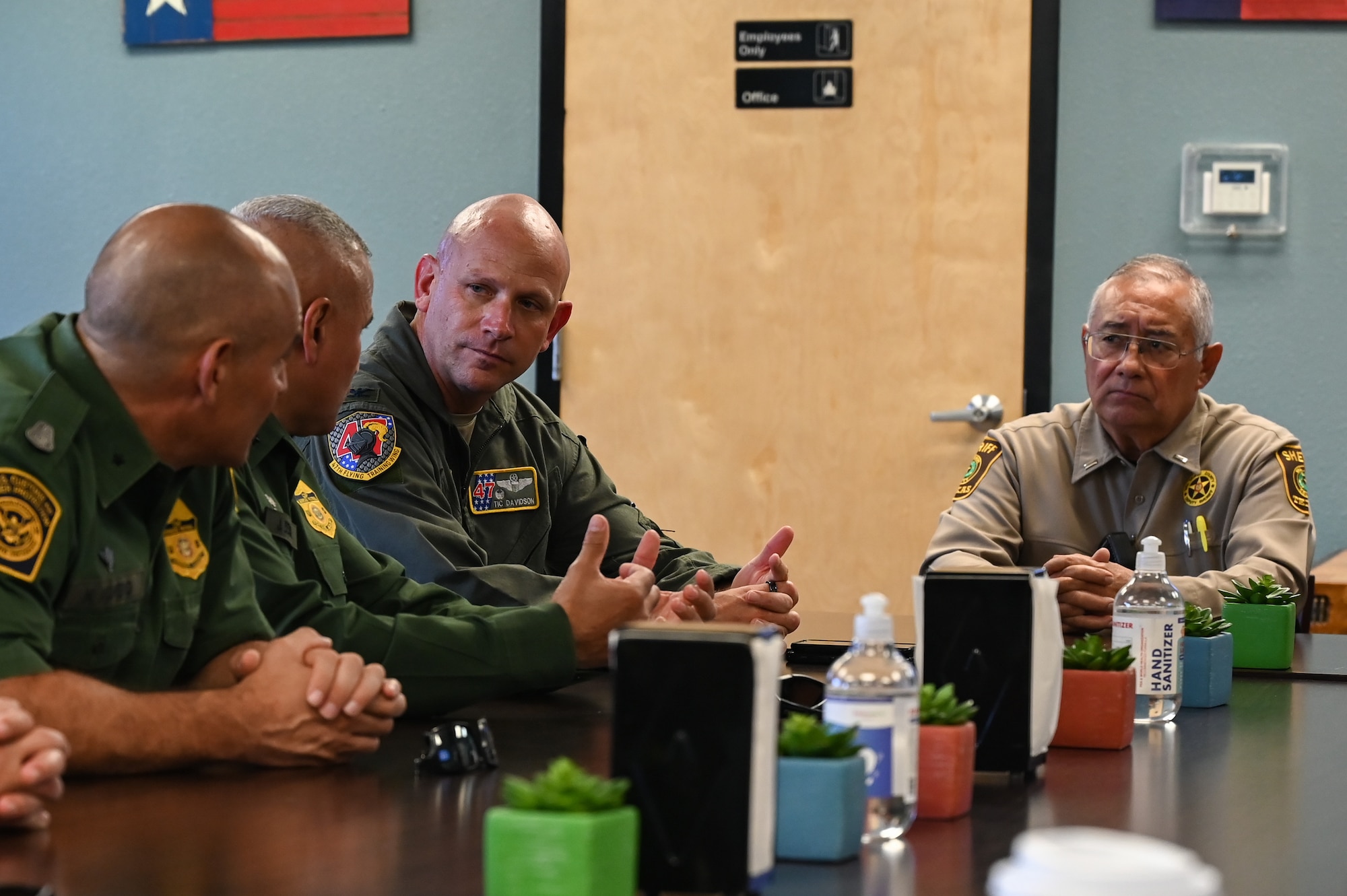 U.S. Air Force Col. Kevin Davidson, 47th Flying Training Wing commander, listens to Acting Chief Patrol Agent Juan Bernal, U.S. Border Patrol, Del Rio Sector, during a base tour with the U.S. Border Patrol, Del Rio Sector leadership and the Val Verde County Sheriff's Department at Laughlin Air Force Base, Texas, Aug. 4, 2023. The main objective of the visit was to strengthen community partnerships to support future cooperation, community safety, and training opportunities. (U.S. Air Force photo by Airman 1st Class Keira Rossman)