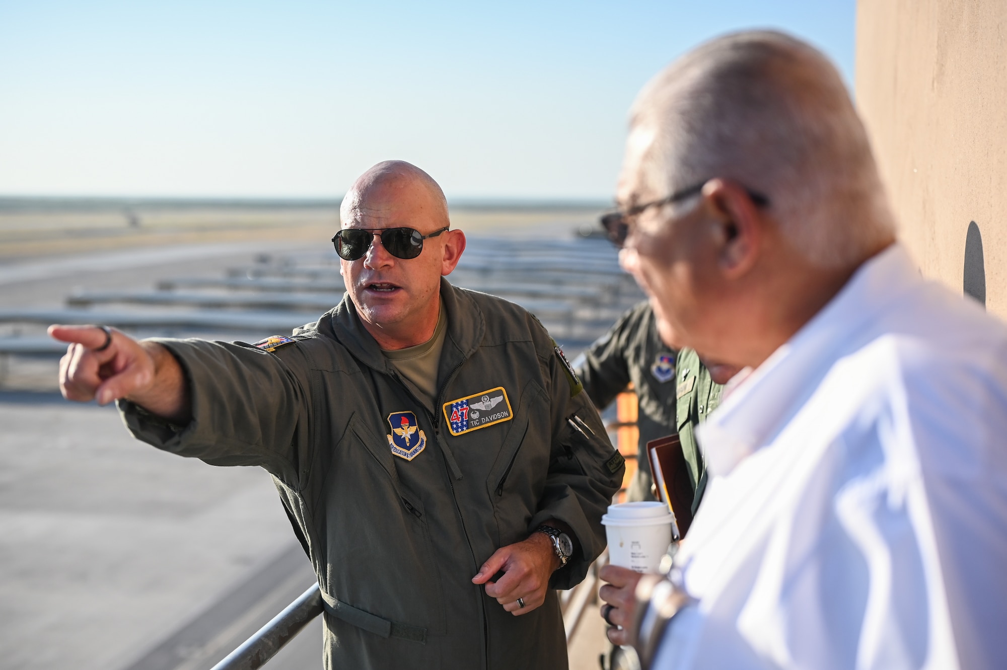 U.S. Air Force Col. Kevin Davidson, 47th Flying Training Wing commander, points at a T-38C Talon at the end of the flightline during a base tour with the leaders from the U.S. Border Patrol, Del Rio Sector and the Val Verde County Sheriff's Department at Laughlin Air Force Base, Texas, Aug. 4, 2023. The primary objective of the visit was to strengthen community partnerships to support future cooperation, community safety, and training opportunities. (U.S. Air Force photo by Airman 1st Class Keira Rossman)