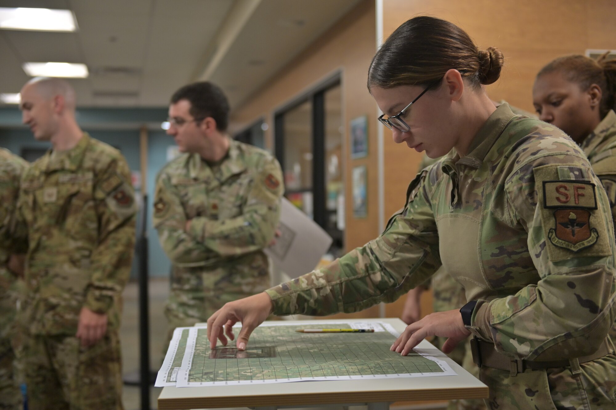Security Forces personnel plot coordinates on a map.