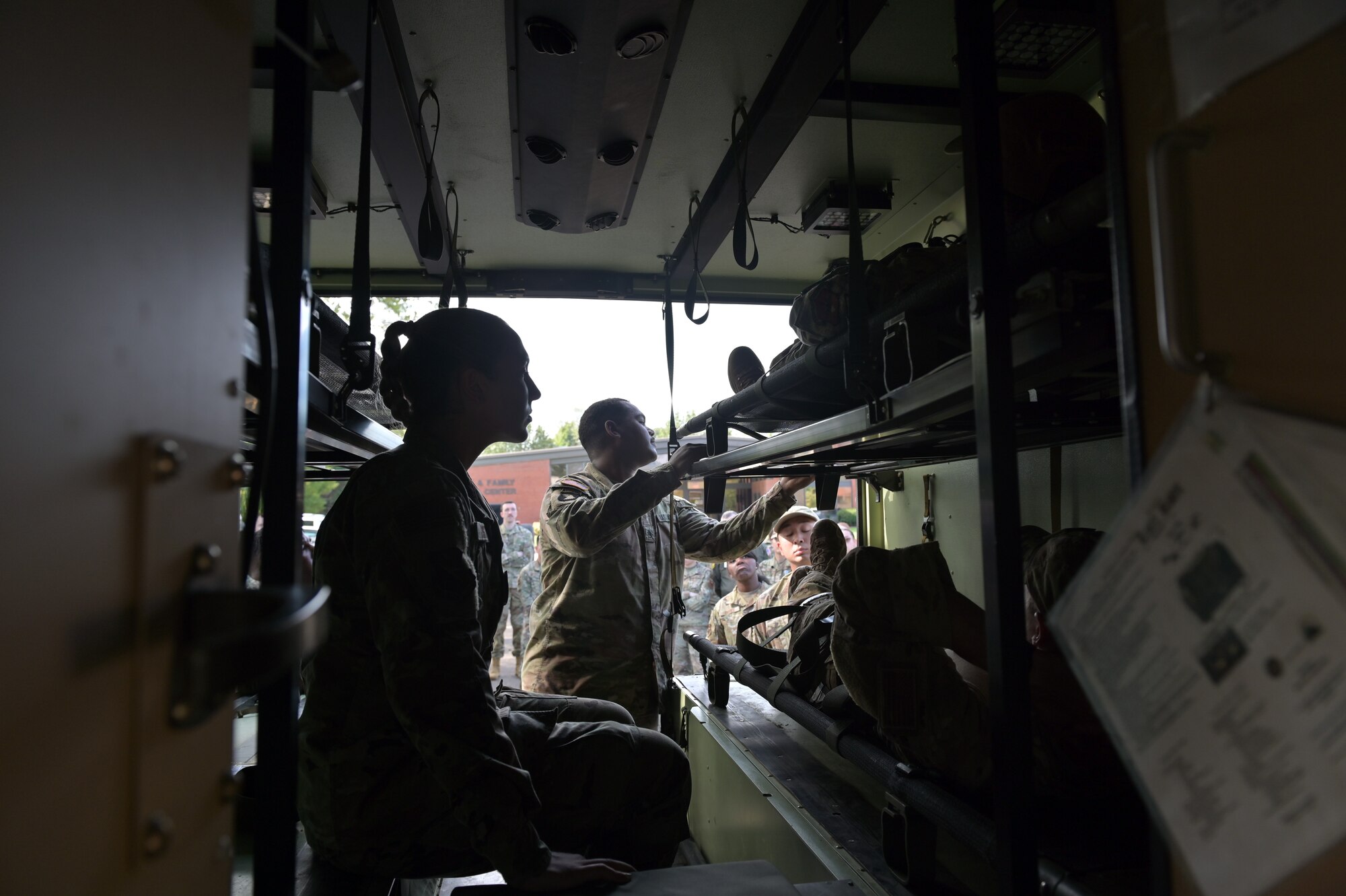 14th Medical personnel practice loading and unloading patients into a military ambulance.
