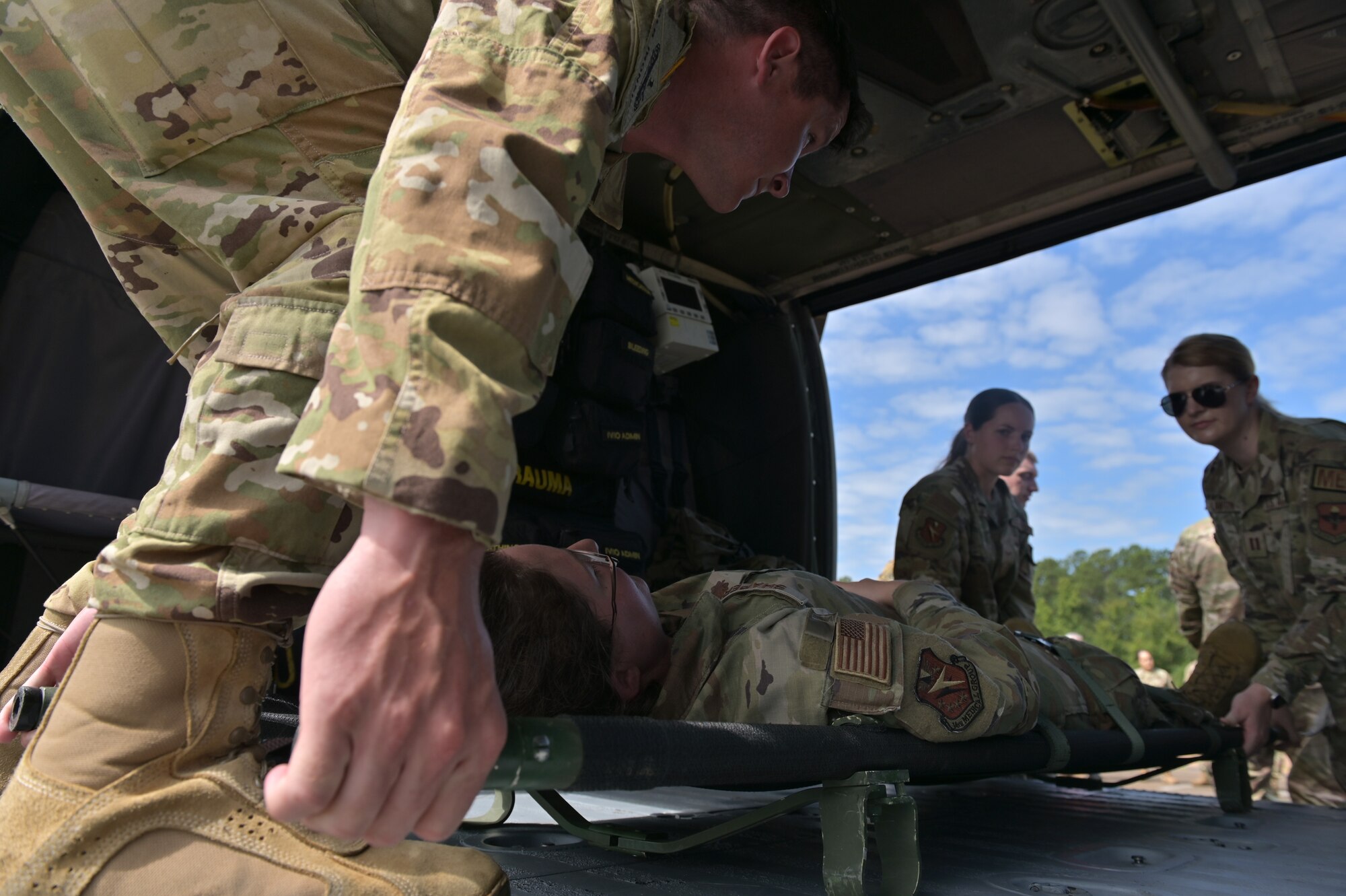 Medical personnel load a simulated patient onto a MH-60 Mississippi Army National Guard helicopter.