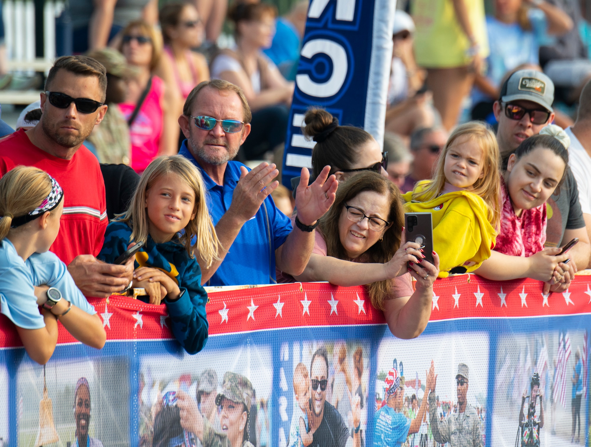 Marathon onlookers cheer on participants with signs.