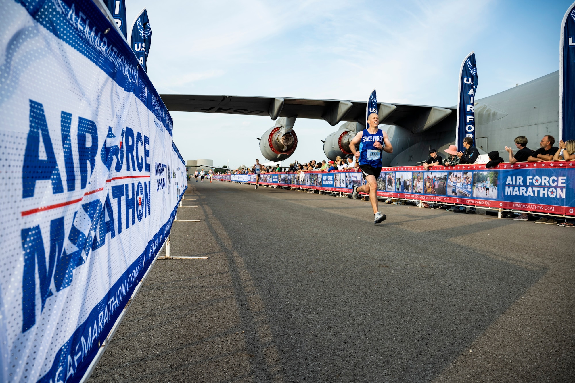 Air Force Marathon sign to the left and runner nearing the finish line.