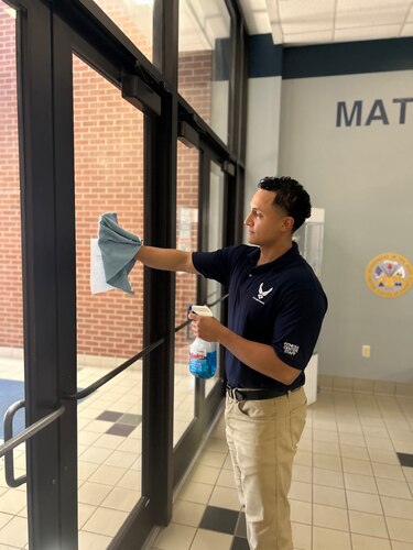 Juan Carlos Jara, Angelo State University Air Force ROTC cadet, cleans windows at the Mathis Fitness Center, Goodfellow Air Force Base, Texas. During his downtime while working at the fitness center, Jara is able to complete his Angelo State University classwork. (Courtesy photo)