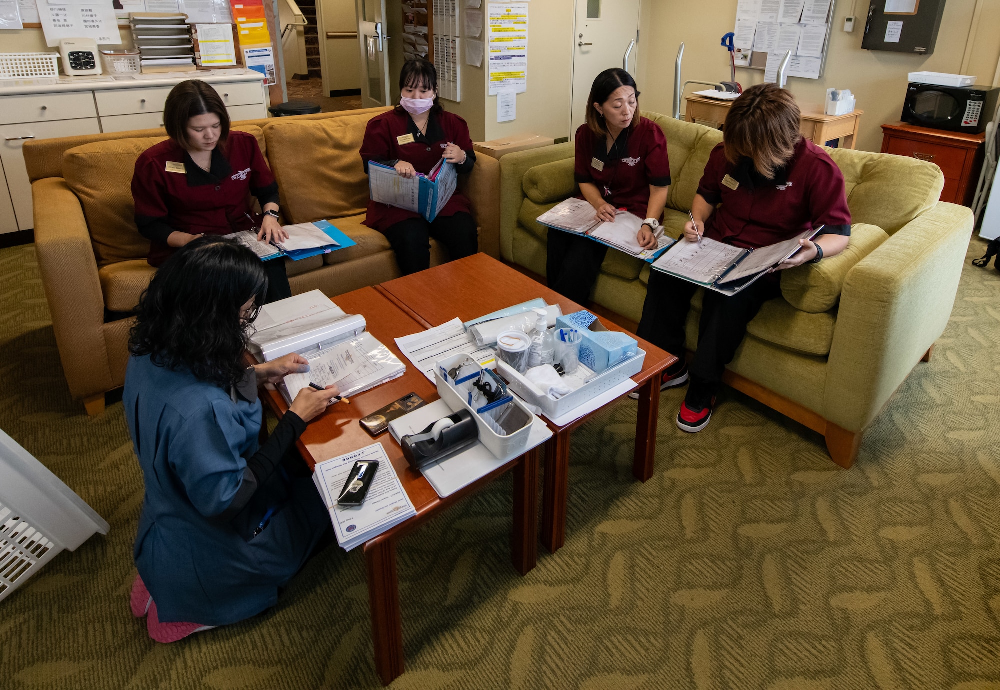 A group of Shogun Inn management discuss plans around a table.