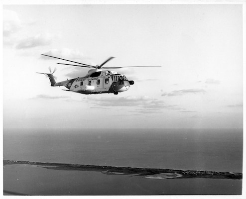 A black & white photograph of a Coast Guard HH3-F “Pelican” flying along the East Coast. (U.S. Coast Guard photo)