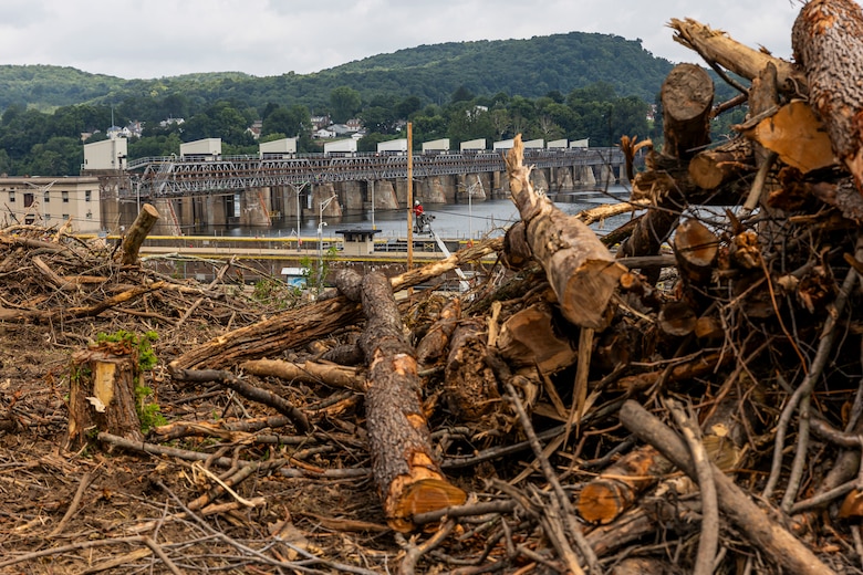 A helicopter lifting trees and concrete blocks to place them in a water basin on the Ohio River.