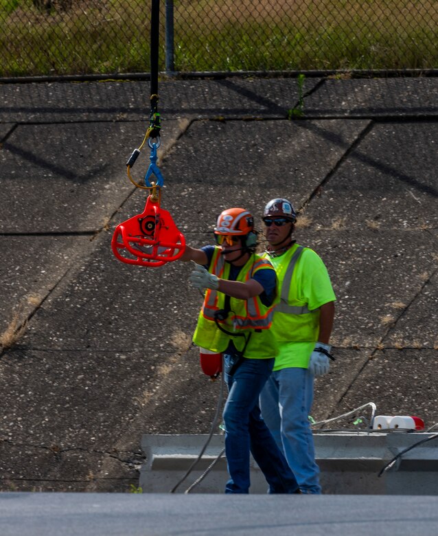 A helicopter lifting trees and concrete blocks to place them in a water basin on the Ohio River.