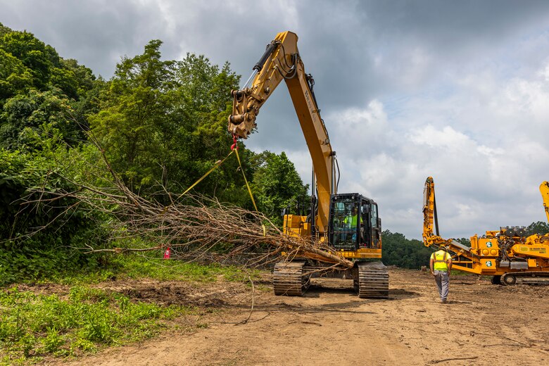 A helicopter lifting trees and concrete blocks to place them in a water basin on the Ohio River.