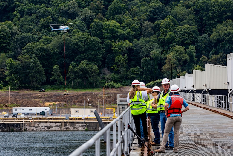 A helicopter lifting trees and concrete blocks to place them in a water basin on the Ohio River.
