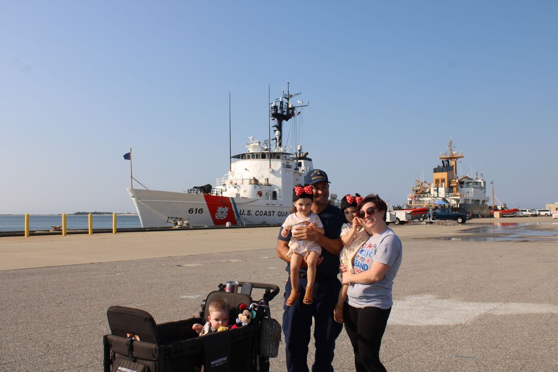 U.S. Coast Petty Officer 1st Class Nicholas Rozansky, a gunner's mate assigned to Guard Cutter Dauntless (WMEC 624), poses for a photo with his family at the unit's return to homeport in Pensacola, Florida, Aug. 19, 2023. The Dauntless crew completed a 42-day patrol in the Windward Passage. (U.S. Coast Guard photo by courtesy of Dauntless)