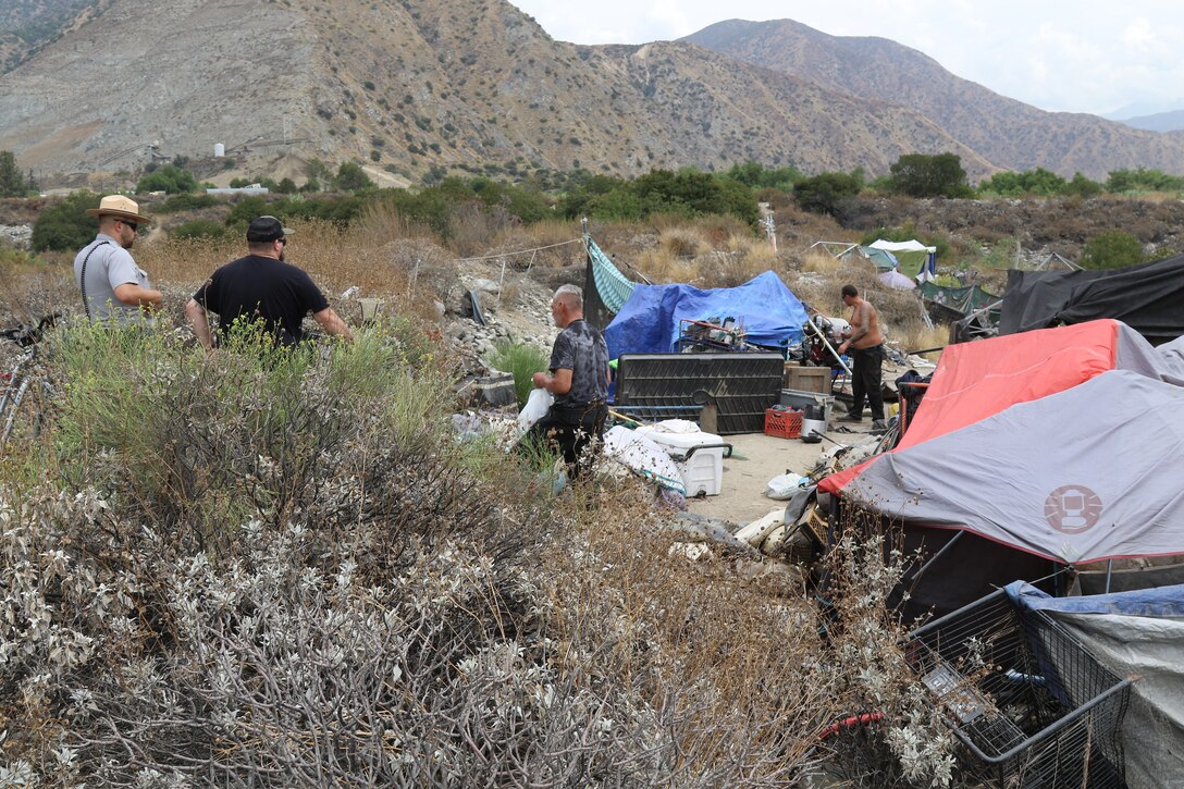 U.S. Army Corps of Engineers Los Angeles District Park Ranger Nick Figueroa and Trevor Snyder, program manager and homeless encampment liaison with the Corps’ LA District, along with law enforcement officers with the Azusa Police Department (not pictured) speak with two homeless individuals living in the riverbed of the Santa Fe Dam Aug. 19 in Azusa, California. Multiple law enforcement agencies, including the LA County Sheriff’s Department’s Homeless Outreach Service’s Team, Azusa and Irwindale police departments; the U.S. Army Corps of Engineers Los Angeles District’s Operations Division; and the Los Angeles Homeless Services Authority collaborated on efforts to evacuate homeless individuals near the dam to safety prior to the impending tropical storm Hurricane Hilary.