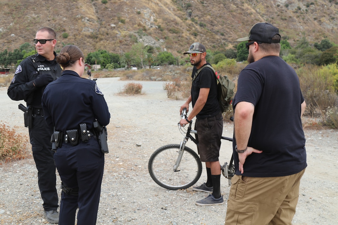 Sgt. Steve Sears and Officer K. Sandoval with the Azusa Police Department, along with Trevor Snyder, program manager and homeless encampment liaison with the U.S. Army Corps of Engineers Los Angeles District, speak with a homeless individual Aug. 19 near the Santa Fe Dam in Azusa, California. Multiple law enforcement agencies, including the LA County Sheriff’s Department’s Homeless Outreach Service’s Team, Azusa and Irwindale police departments; the U.S. Army Corps of Engineers Los Angeles District’s Operations Division; and the Los Angeles Homeless Services Authority collaborated on efforts to evacuate homeless individuals near the dam to safety prior to the impending tropical storm Hurricane Hilary.