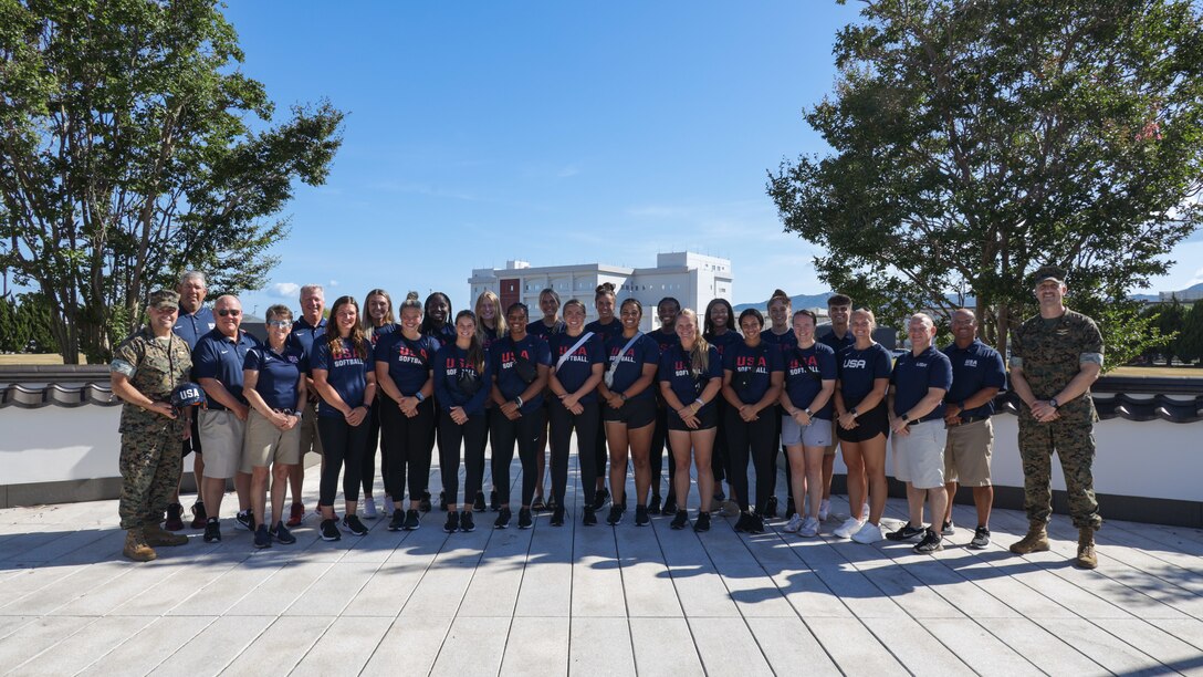 Members of the USA Women's National Softball Team, and leadership from Marine Corps Air Station Iwakuni pose for a group photo at MCAS Iwakuni, Japan, July, 28, 2023. The Women’s National Team partnered with the city of Iwakuni and Marine Corps Community Services Iwakuni to host a softball clinic and a USA vs Japan softball game. (U.S. Marine Corps photo by Cpl. Darien Wright)